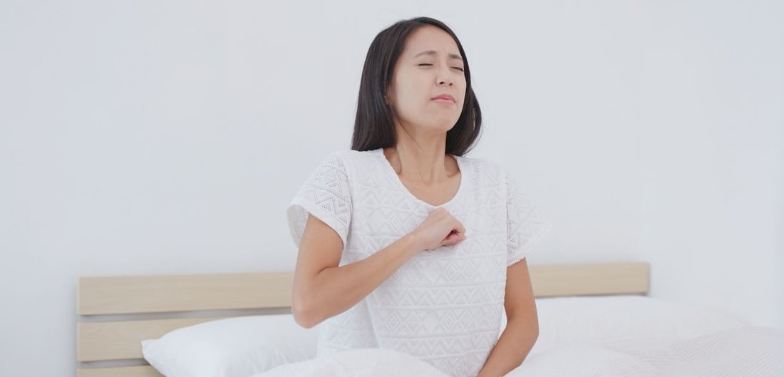 Frau bekommt Rückenschmerzen beim Atmen