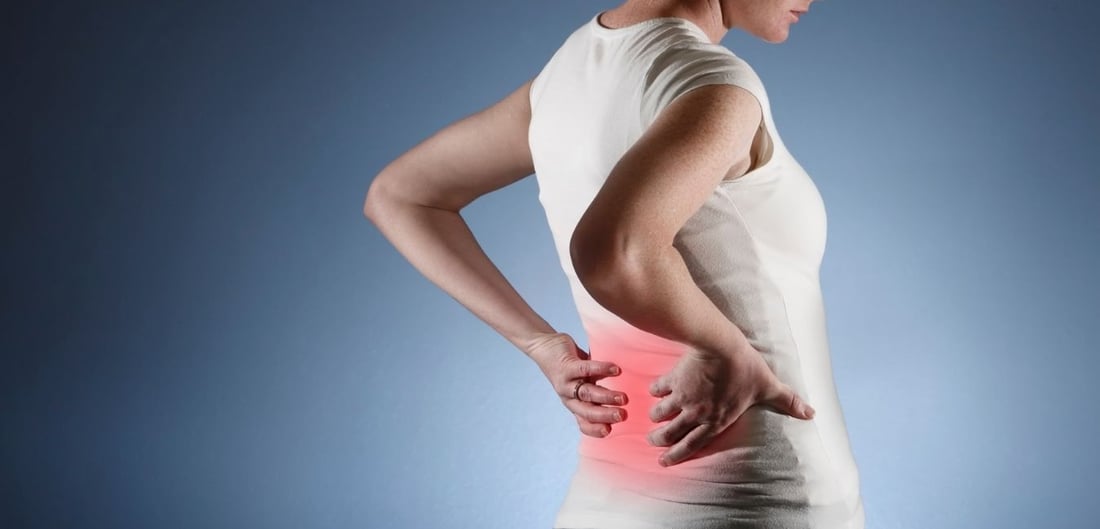 Frau leidet unter akuten punktuellen Rückenschmerzen